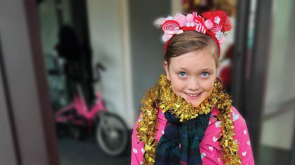 Violet wearing a tinsel scarf and smiling.