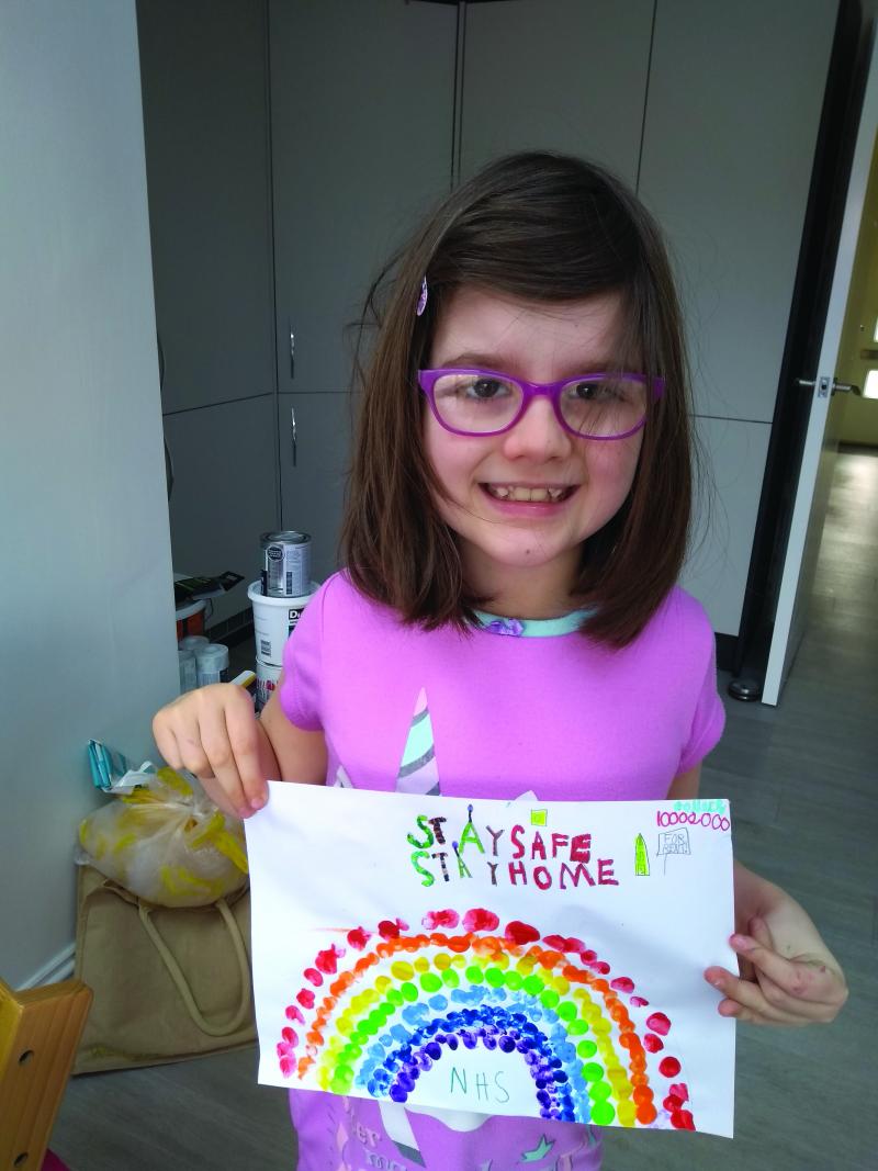 Emma holding a picture of a rainbow