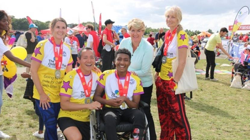 group of people wearing The Children's Trust t-shirts at the finish line of the Superhero Tri